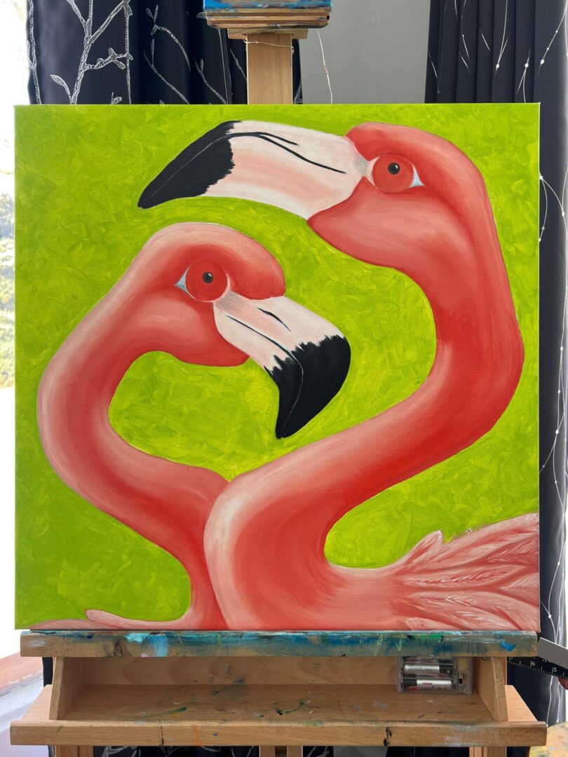 Two flamingos are standing next to each other.